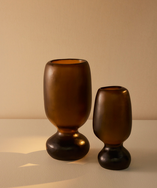 Organic shaped vases with cinched waists, the two Rockpool Vases in Tall and Extra Large sizes appear in warm sunlight in a colour way reminiscent of Honey 