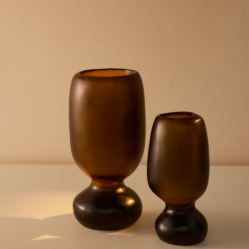 Organic shaped vases with cinched waists, the two Rockpool Vases in Tall and Extra Large sizes appear in warm sunlight in a colour way reminiscent of Honey 
