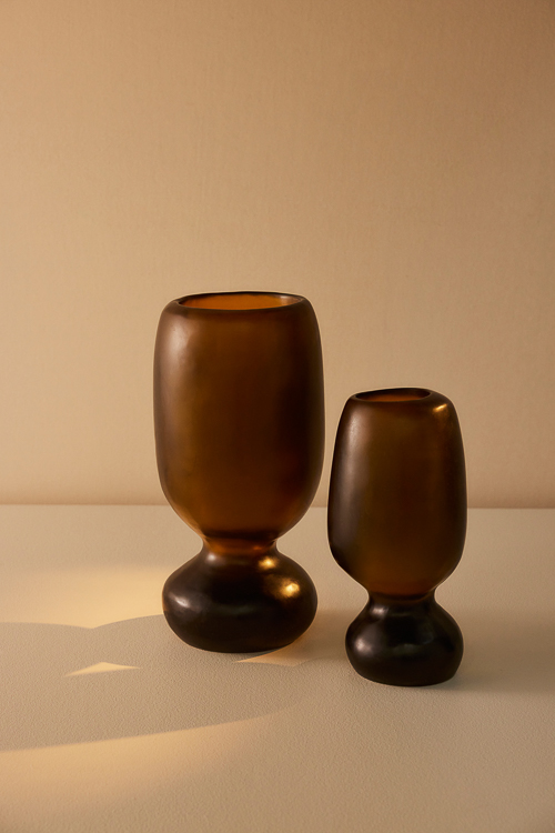 Organic shaped vases with cinched waists, the two Rockpool Vases in Tall and Extra Large sizes appear in warm sunlight in a colour way reminiscent of Honey 