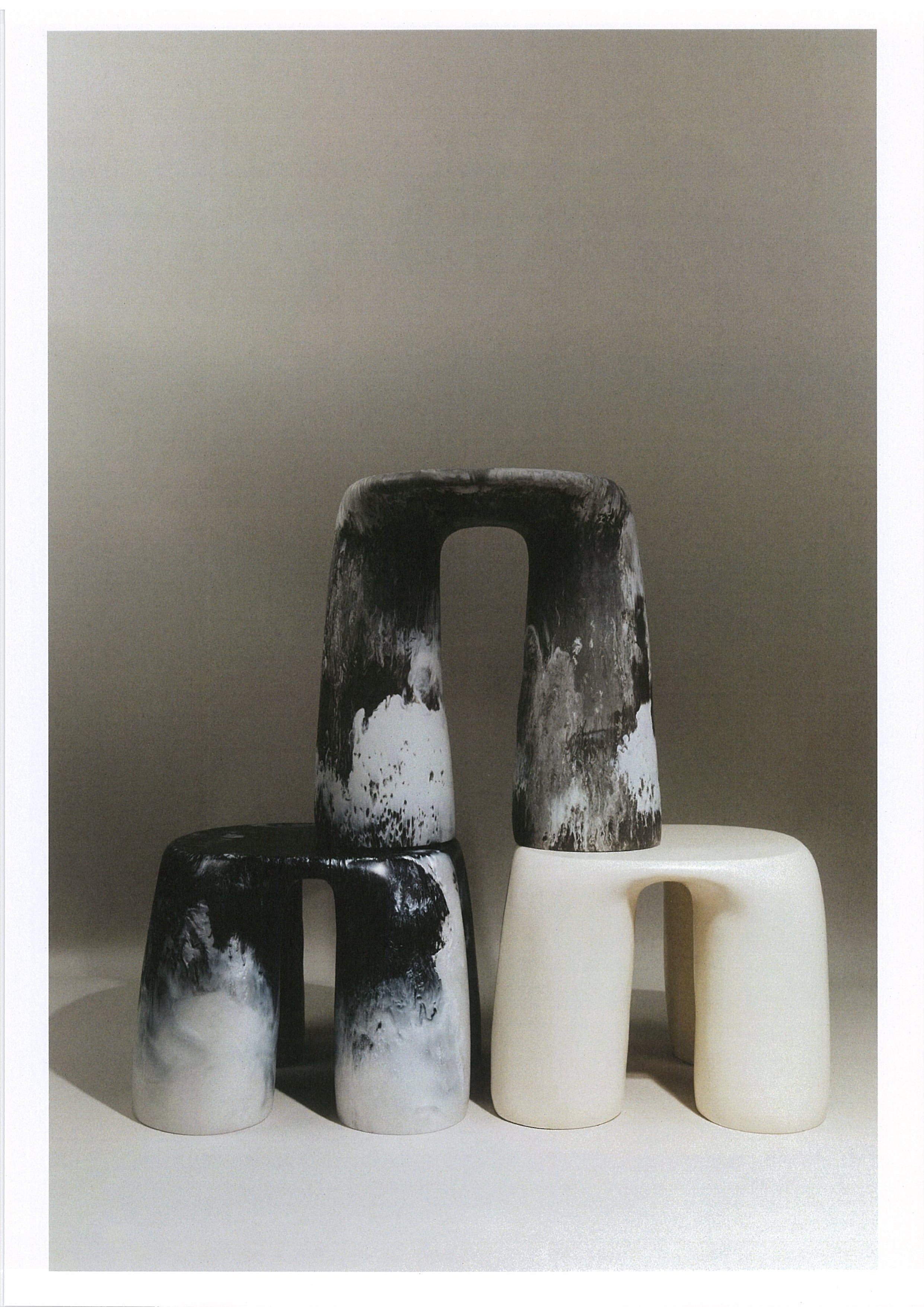 Three abstract resin side tables stacked on a neutral background