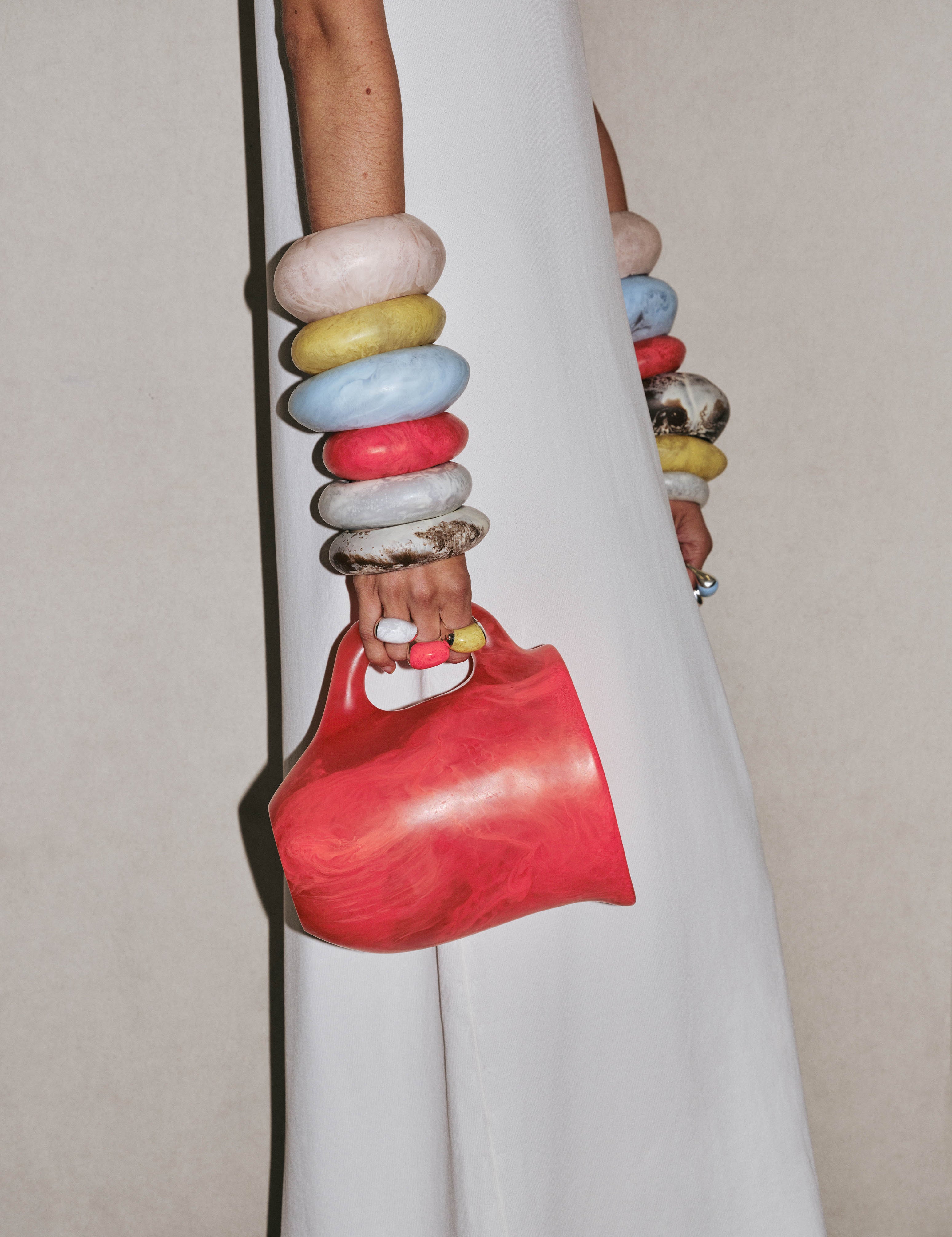 Model with bright coloured bangles holding a pink resin water jug