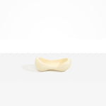 Dinosaur Designs Bones Dish in Cream — handcrafted cream resin trinket dish with pinched bone-shaped organic form