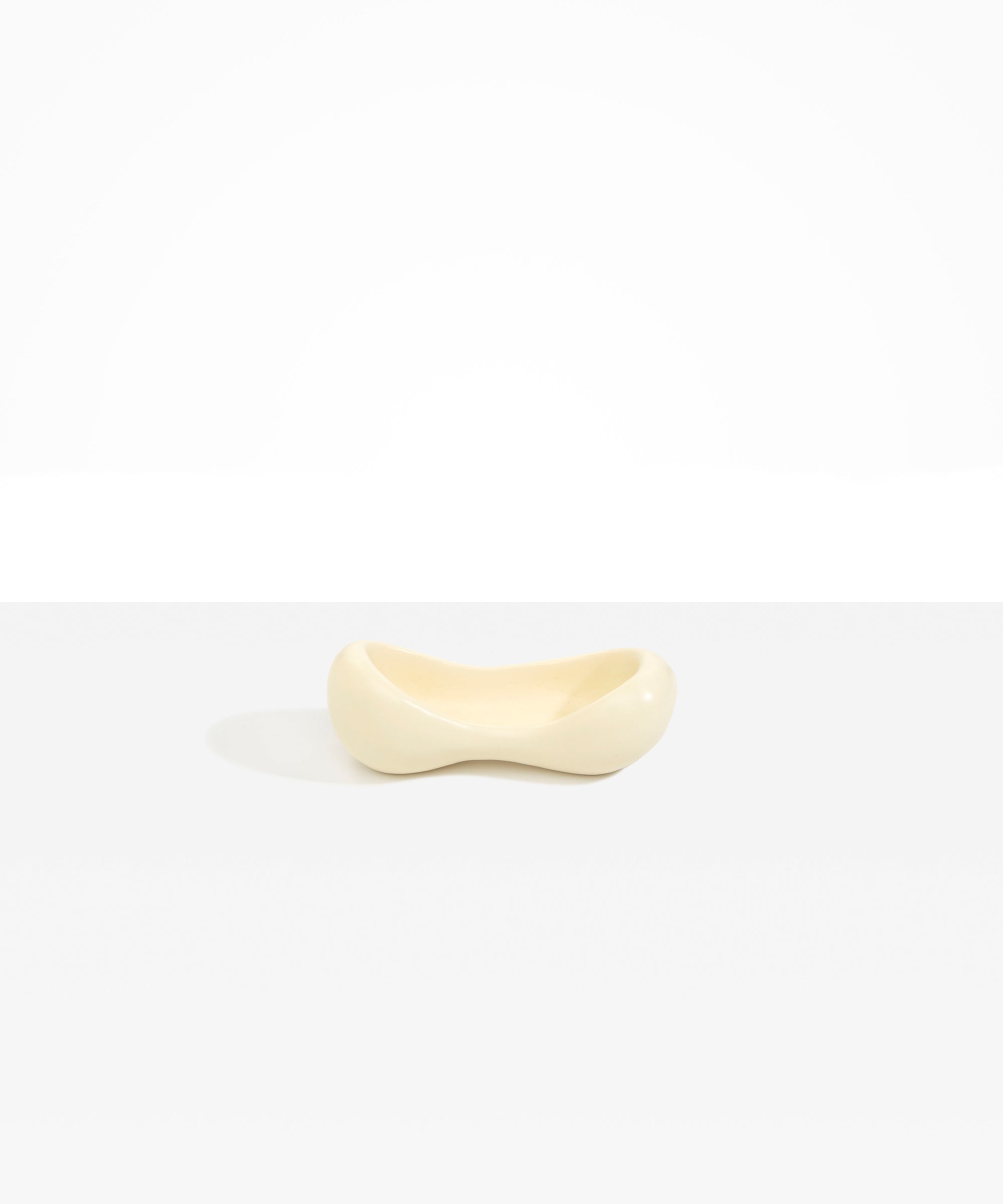 Dinosaur Designs Bones Dish in Cream — handcrafted cream resin trinket dish with pinched bone-shaped organic form