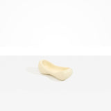 Dinosaur Designs Bones Dish in Cream — handcrafted cream resin trinket dish with pinched bone-shaped organic form