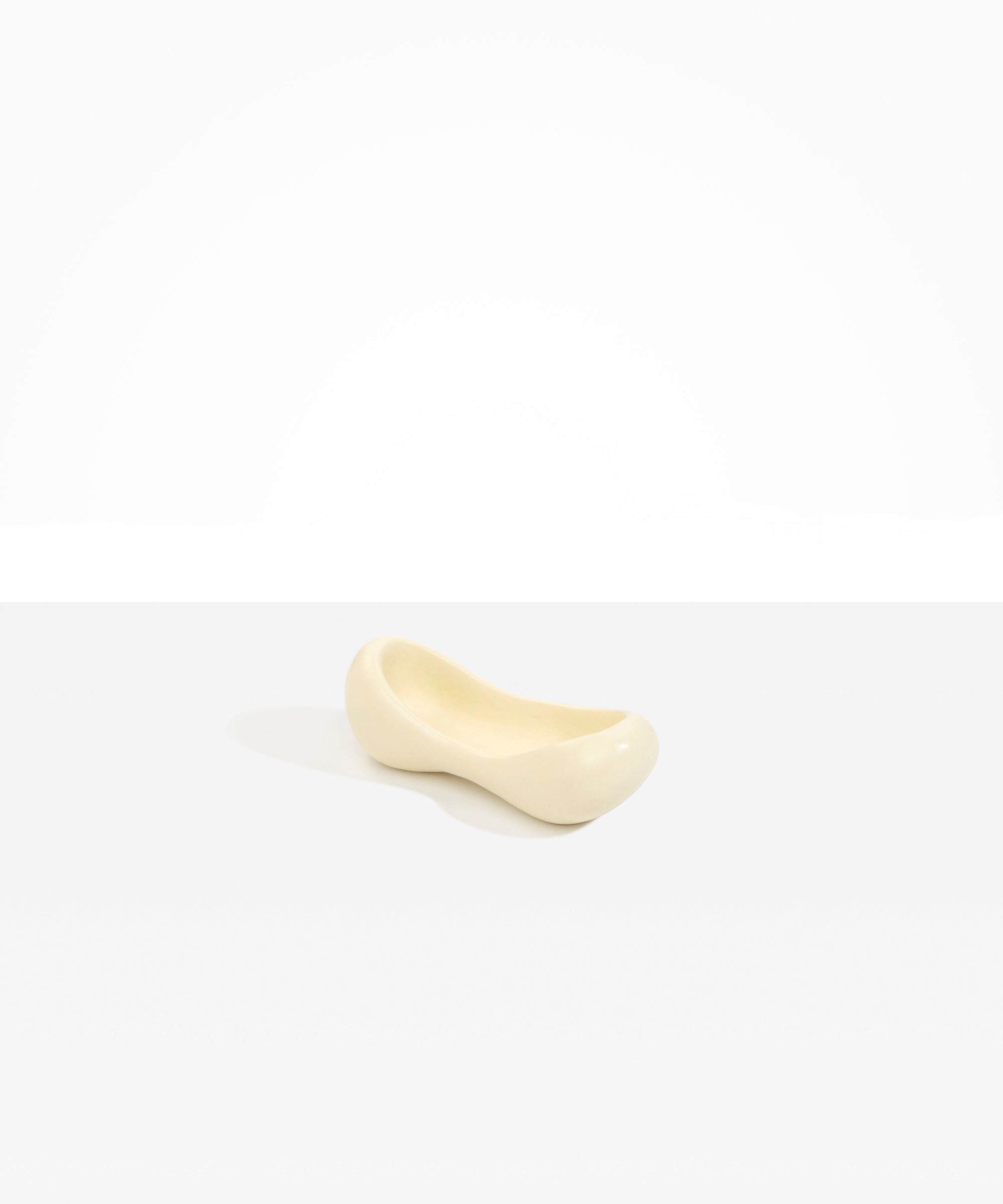 Dinosaur Designs Bones Dish in Cream — handcrafted cream resin trinket dish with pinched bone-shaped organic form