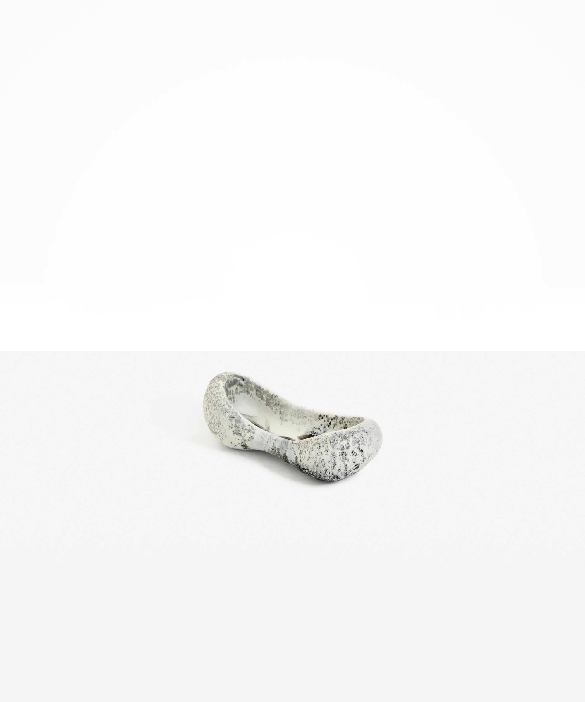 Dinosaur Designs Bones Dish in Granite — handcrafted marbled grey and cream resin trinket dish with pinched bone-shaped organic form.