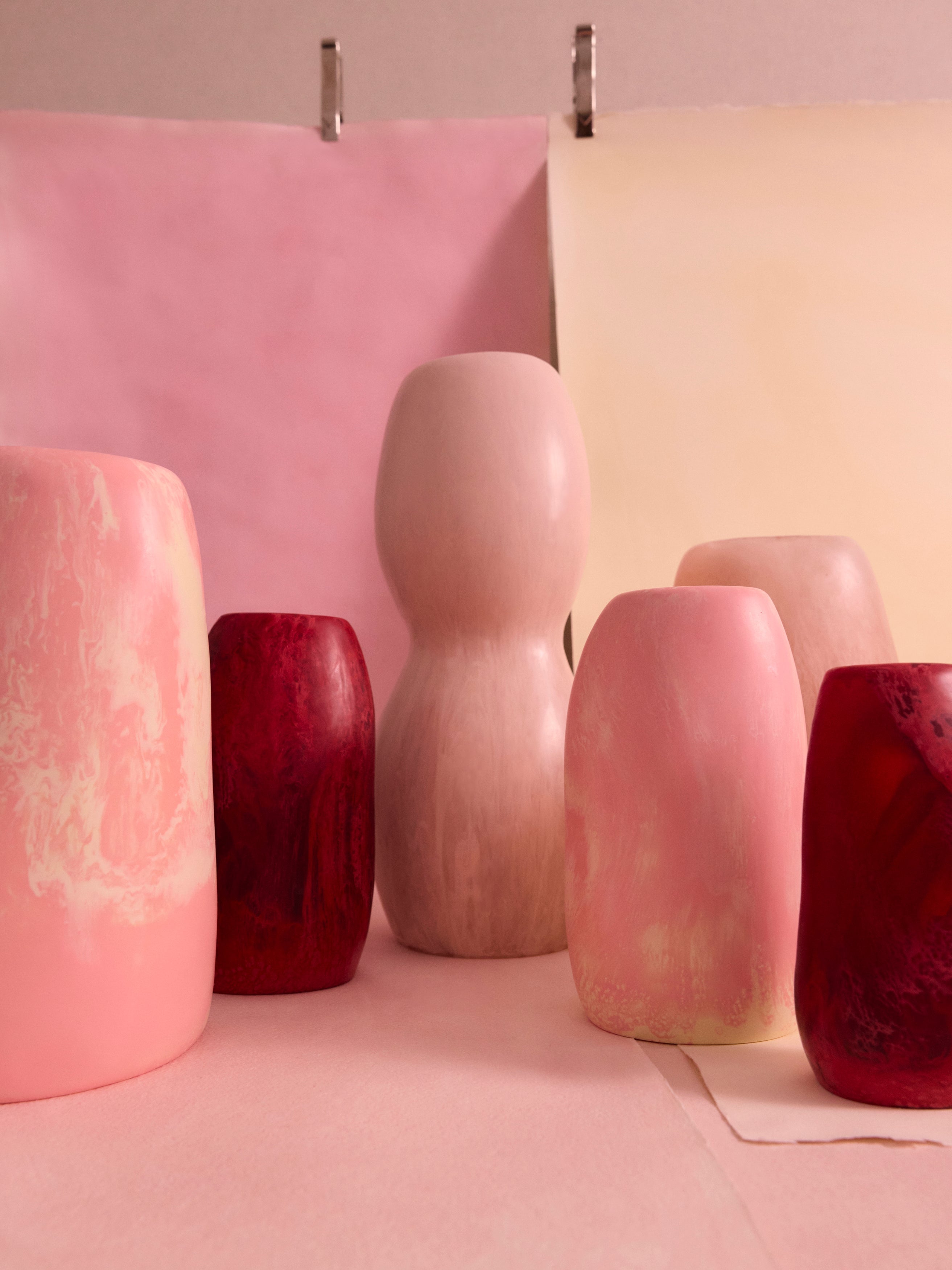 Variety of pink organic shaped vases on a pink and cream backdrop