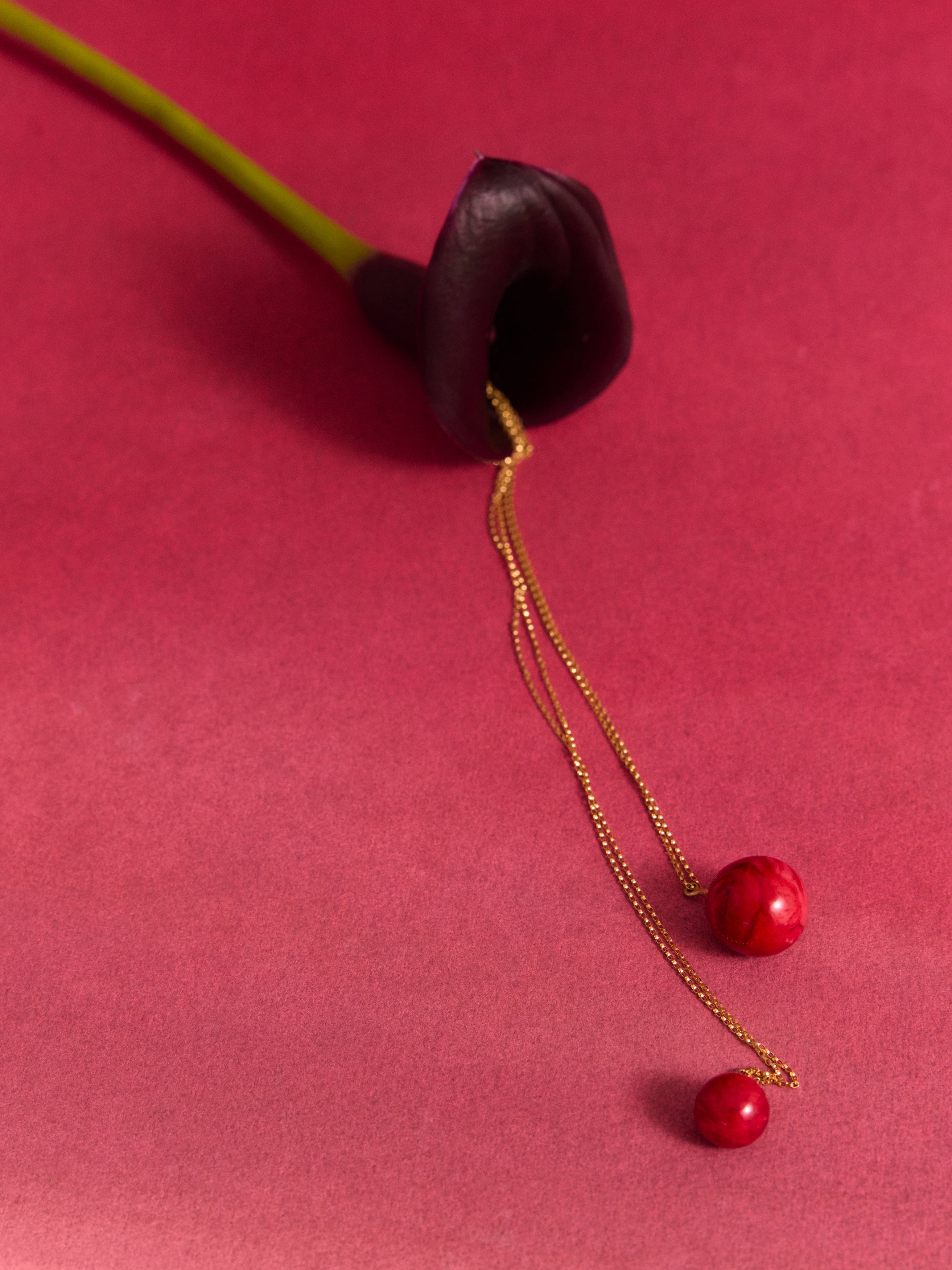 Pink resin ball pendant with a lily, on a pink backdrop
