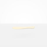 Dinosaur Designs Temple Cake Knife in Cream — handcrafted cream resin cake knife with smooth tapered blade and rounded handle