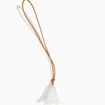 Dinosaur Designs Flower Bag Charm in Chalk Swirl colour with Brass bead — handcrafted marbled off-white resin bell-shaped flower bag charm with tan leather hanging loop and brass bead