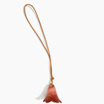 Dinosaur Designs Flower Bag Charm in Rust colour with Brass bead — handcrafted marbled terracotta red and cream resin bell-shaped flower bag charm with tan leather hanging loop and brass bead
