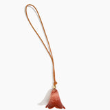 Dinosaur Designs Flower Bag Charm in Rust colour with Brass bead — handcrafted marbled terracotta red and cream resin bell-shaped flower bag charm with tan leather hanging loop and brass bead