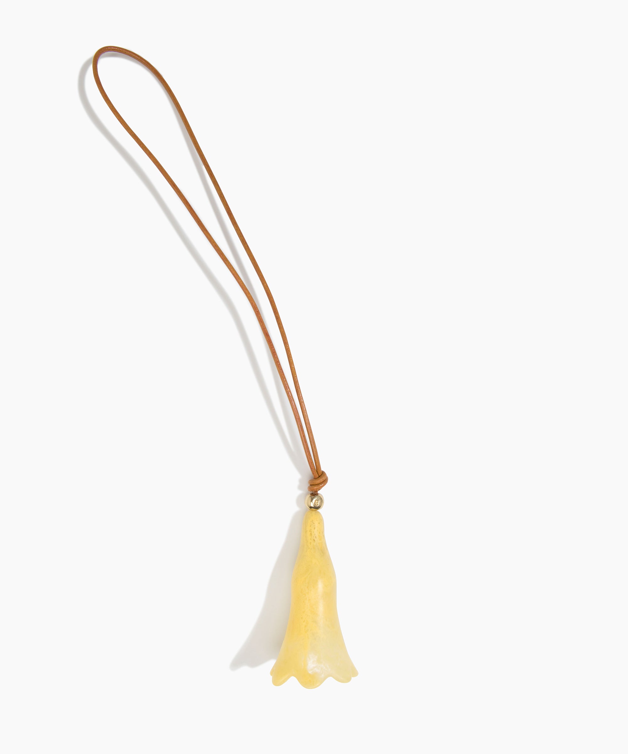 Dinosaur Designs Long Flower Bag Charm in Pollen colour with Brass bead — handcrafted marbled yellow resin bell-shaped flower bag charm with tan leather hanging loop and brass bead