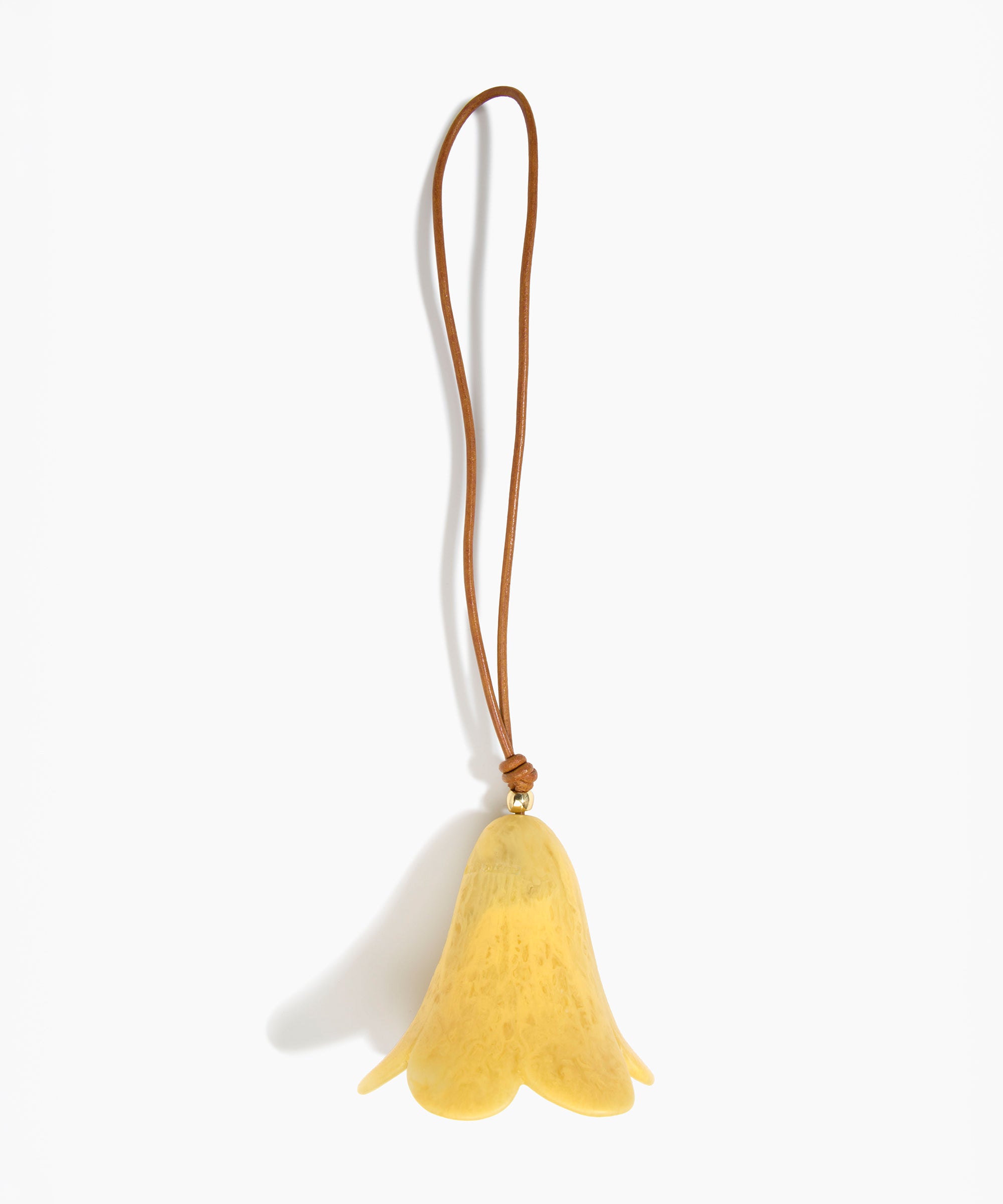 Dinosaur Designs Flower Decoration in Pollen colour with Brass bead — handcrafted marbled yellow resin bell-shaped flower ornament with tan leather hanging loop and brass bead