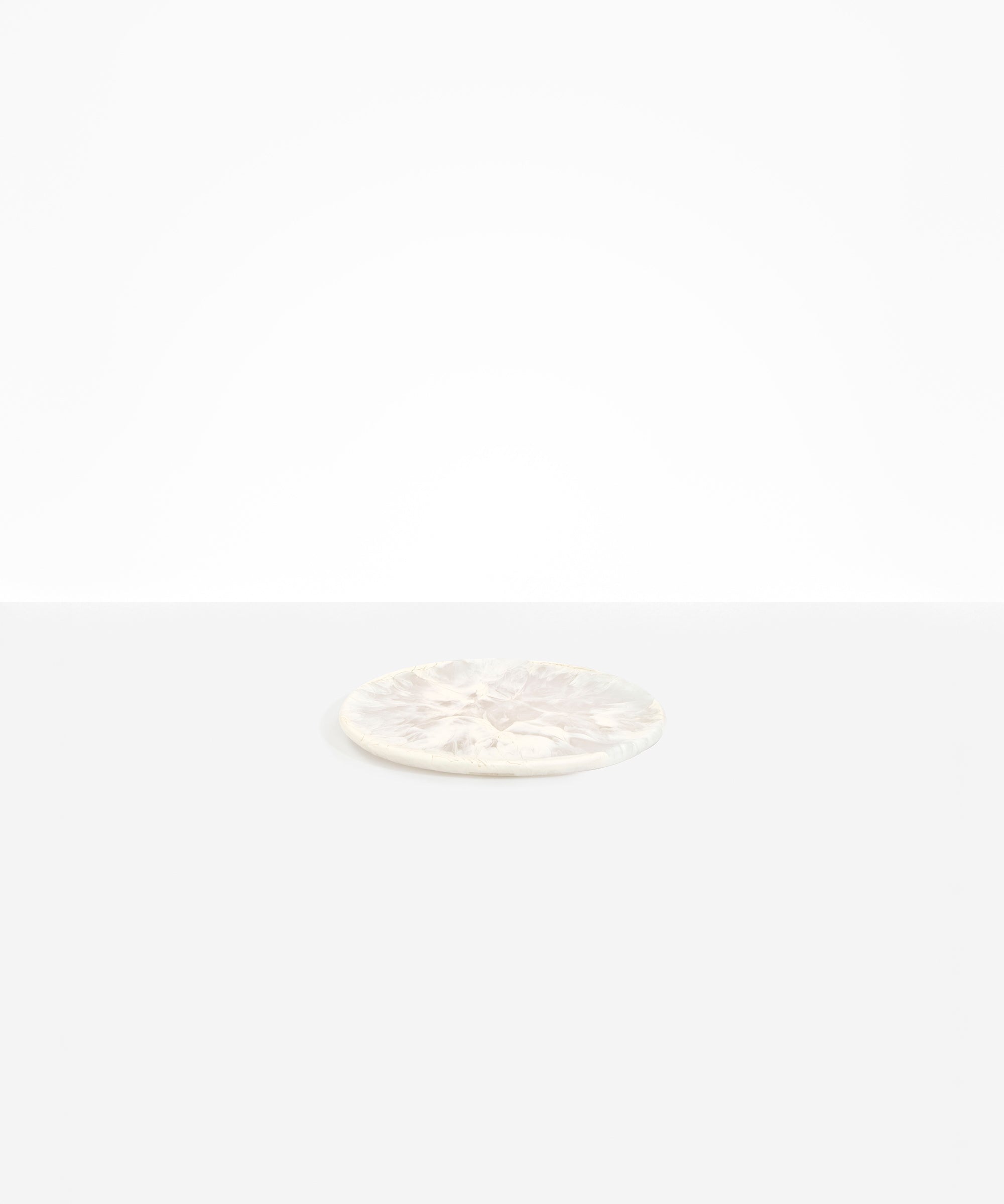 Dinosaur Designs Small Rock Plate in Chalk Swirl — handcrafted marbled off-white resin oval flat serving plate with rounded organic edge