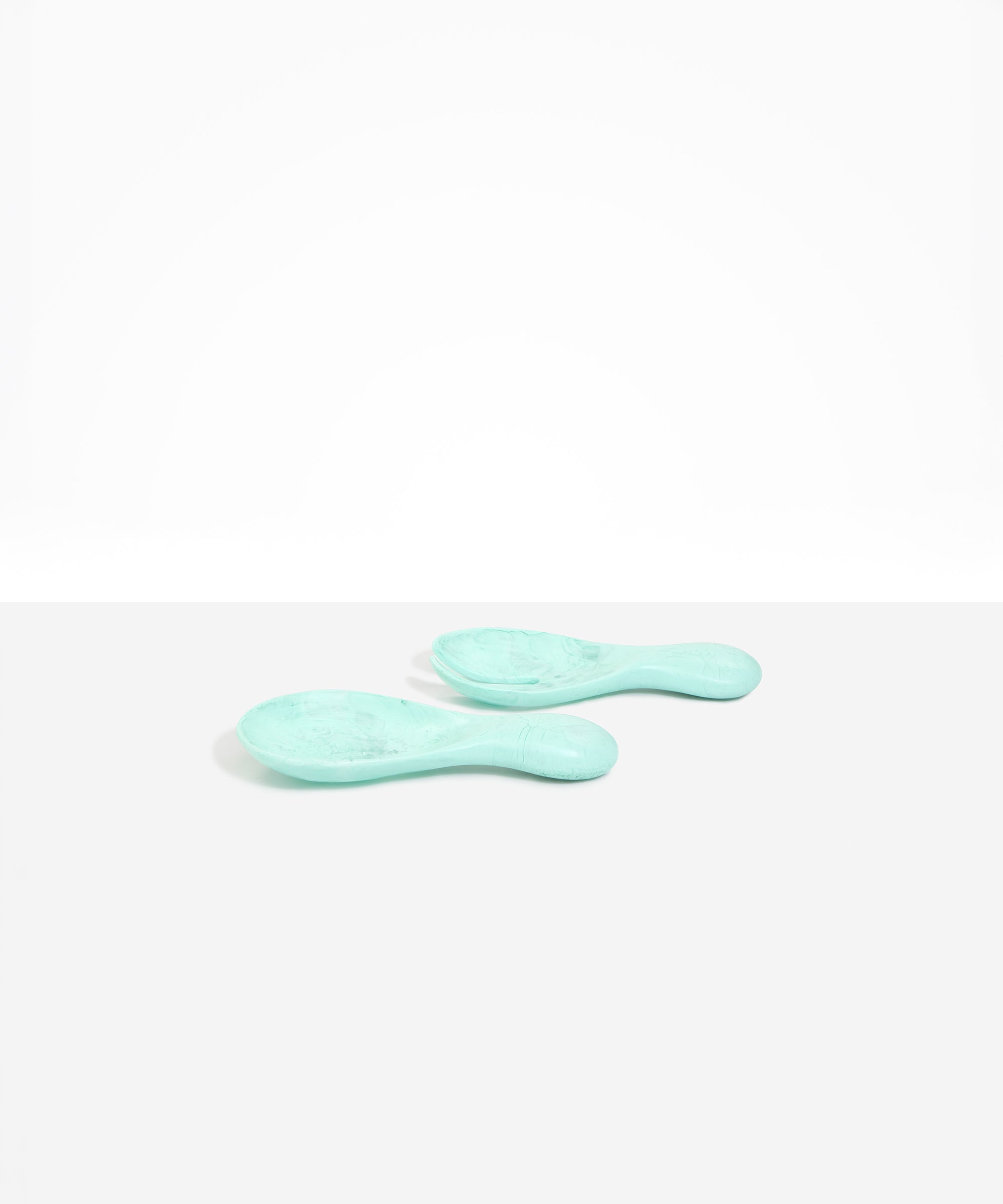 Dinosaur Designs Rock Servers in Mint — handcrafted marbled mint blue resin salad server set with rounded bulb handles, fork and spoon.