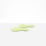 Dinosaur Designs Rock Servers in Pistachio — handcrafted marbled pale green resin salad server set with rounded bulb handles, fork and spoon.