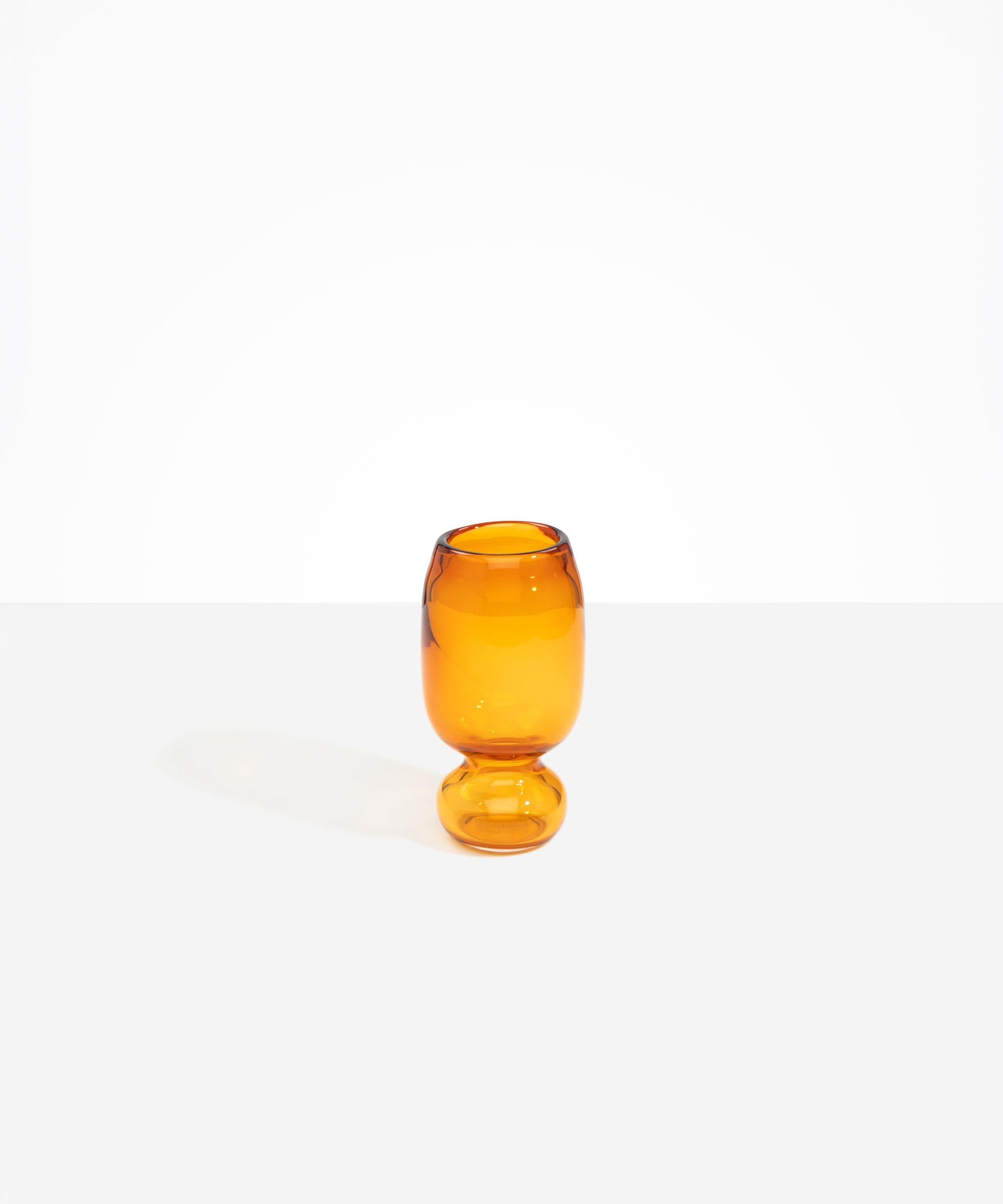 Dinosaur Designs Small Glass Rockpool Vase in Amber — handblown amber glass vase with rounded bulbous body and small spherical pedestal base