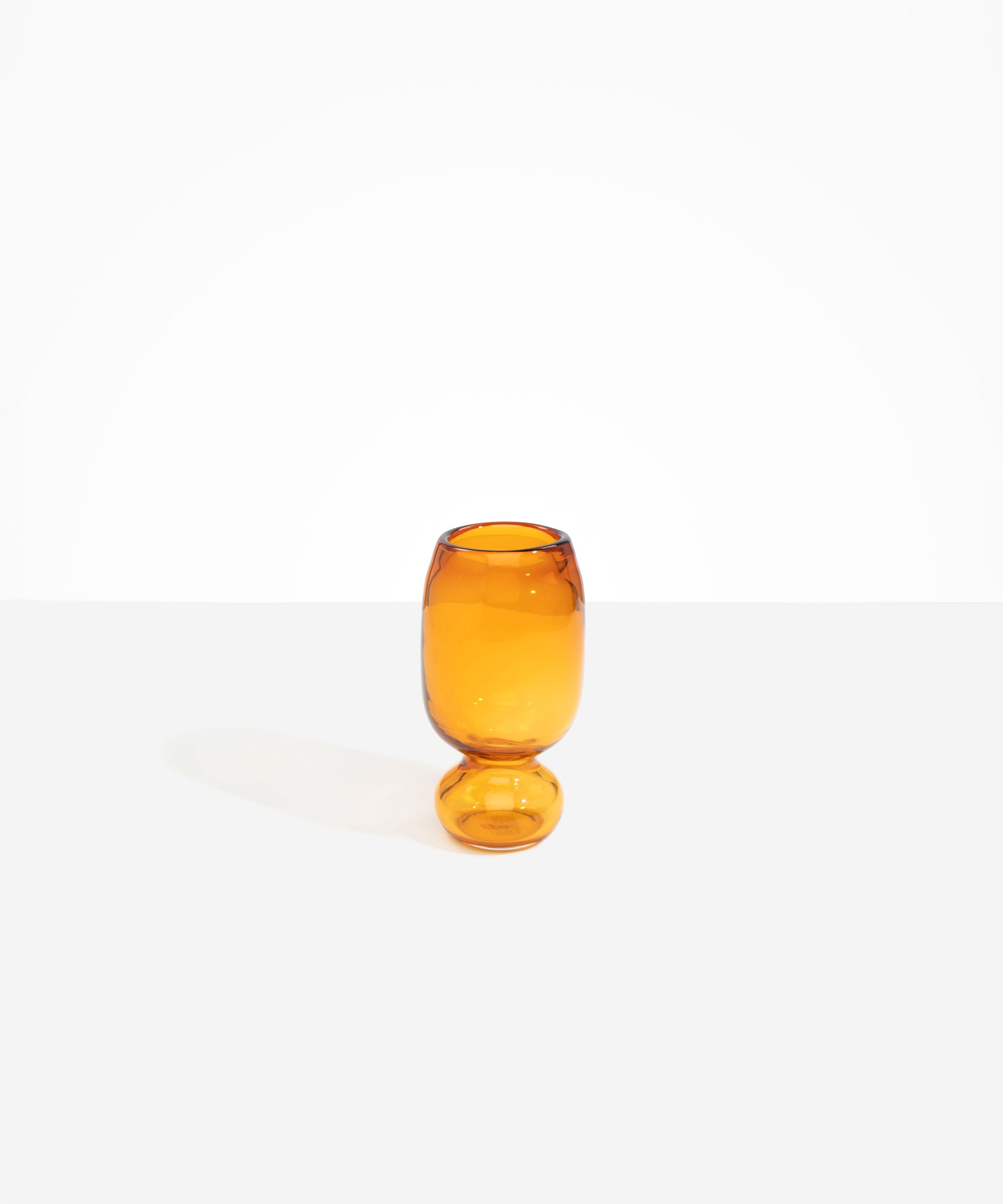 Dinosaur Designs Small Glass Rockpool Vase in Amber — handblown amber glass vase with rounded bulbous body and small spherical pedestal base