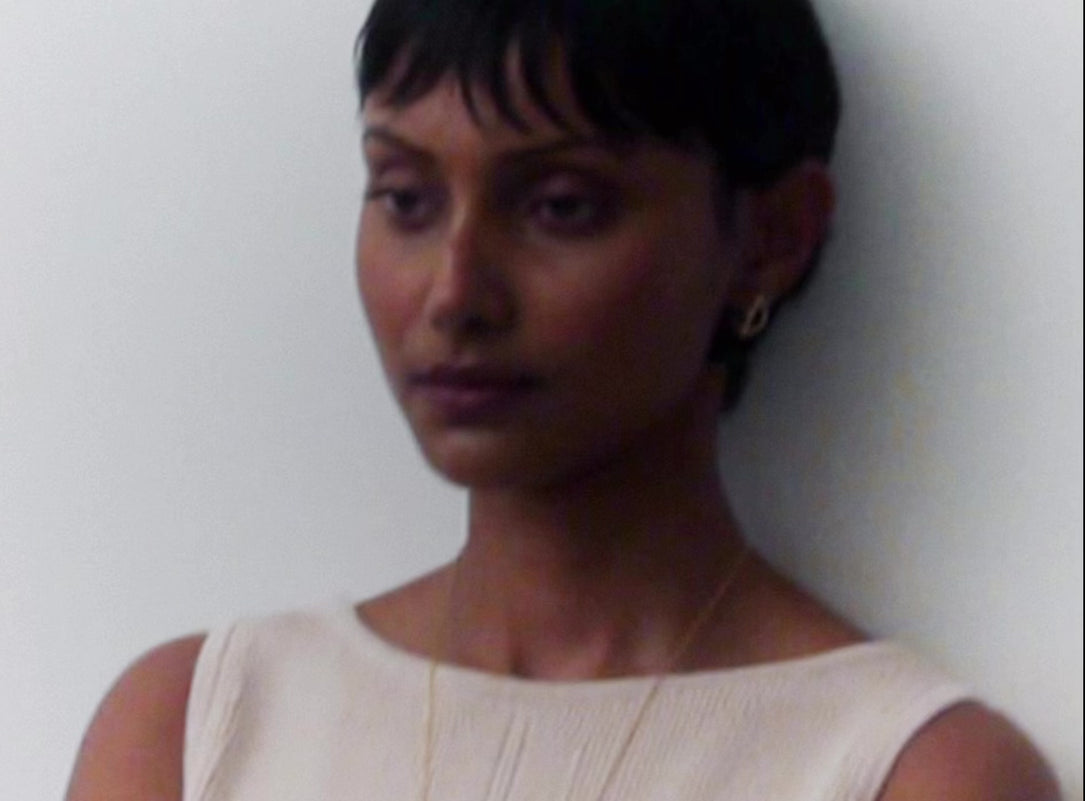 model wearing variety of cream resin bangles and rings with brass accents